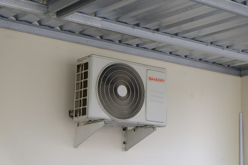 Unidade condensadora de ar-condicionado fixada em parede com suporte metálico