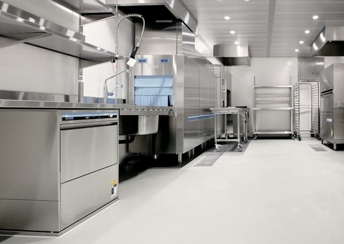 Cozinha comercial com bancadas e equipamentos de aço inox