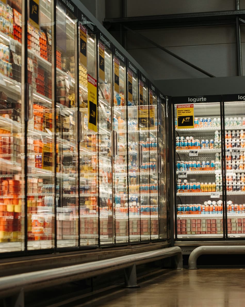 Expositores refrigerados de vidro em corredor de supermercado